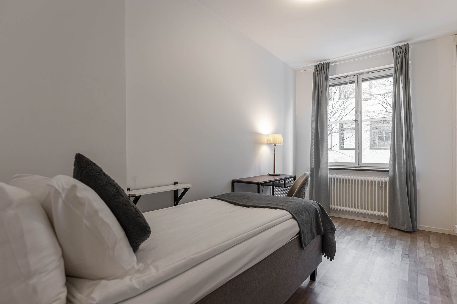 Bright family room at Hotel Arkad in Västerås with a sofa bed, seating area and window.
