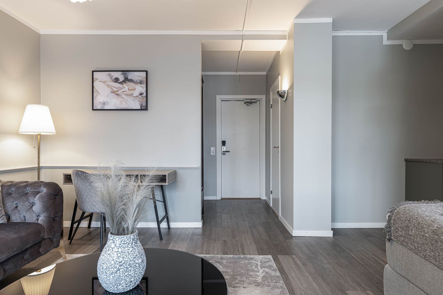 Triple room at Hotel Arkad in Västerås with a seating area, desk and modern interior.