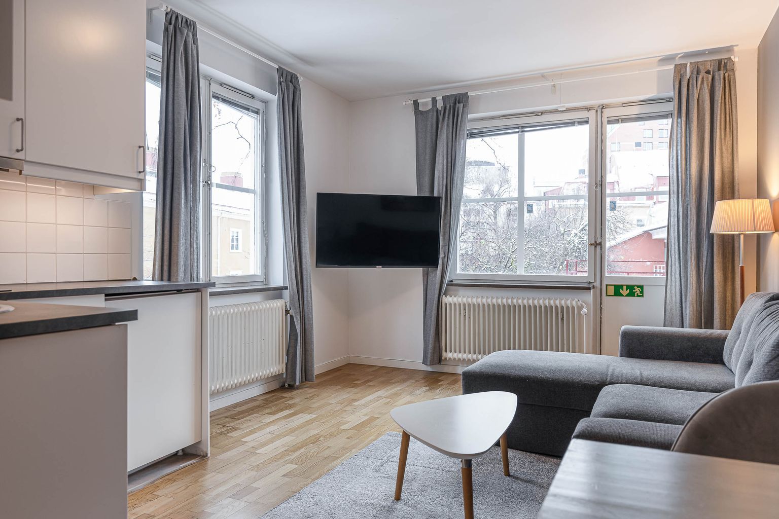 Family room at Hotel Arkad in Västerås with a kitchenette, dining area and large windows.