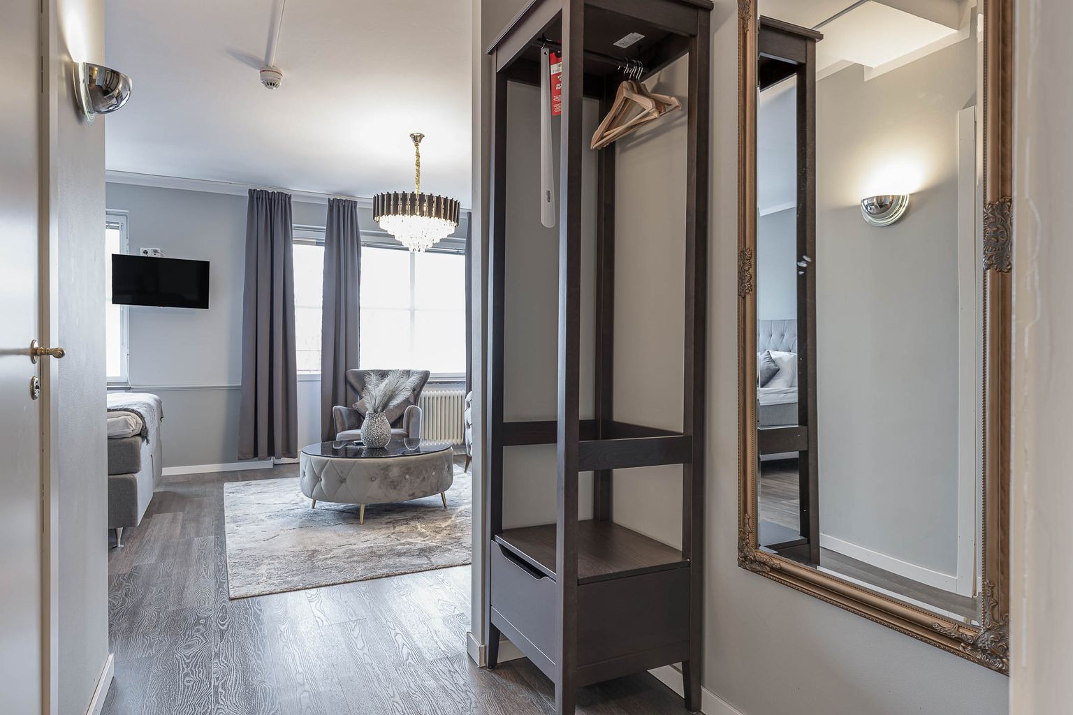 Junior Suite Deluxe at Hotel Arkad in Västerås with an elegant entrance, mirrors and stylish interior.