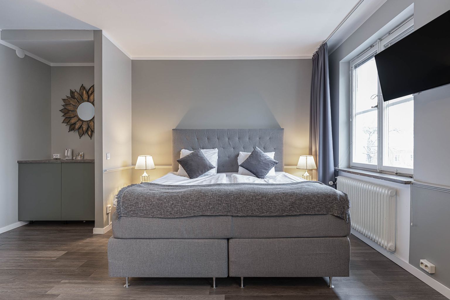 Bedroom in the Junior Suite Deluxe at Hotel Arkad in Västerås with a double bed, window and modern interior.