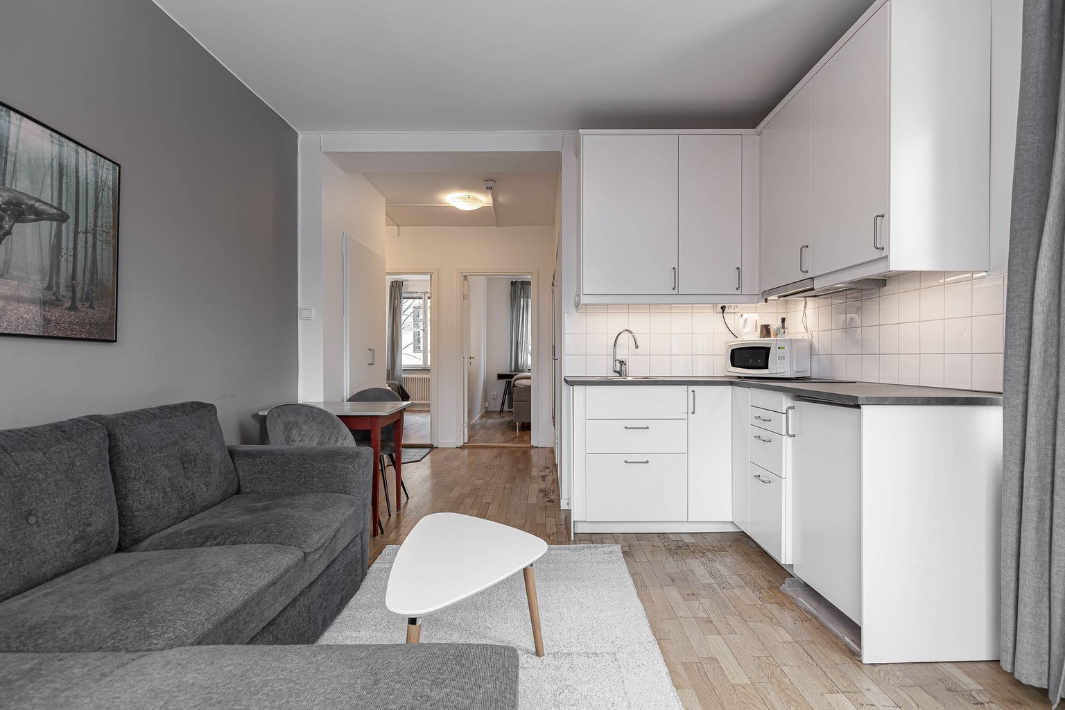Spacious family room at Hotel Arkad in Västerås with a kitchenette, dining area and seating area.