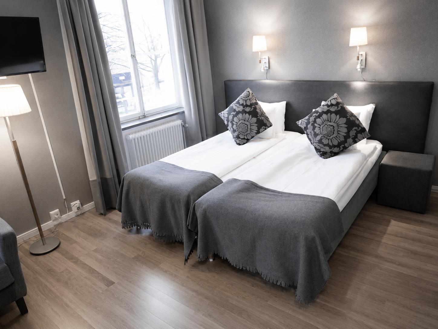 Bright Economy double room at Hotel Arkad in Västerås with two beds, a window and stylish interior.